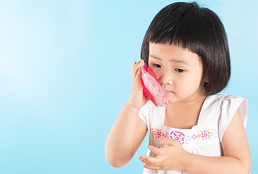 a child with an ice pack on their mouth