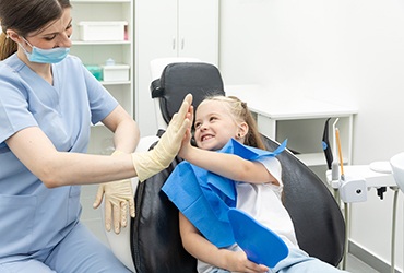 Child high-fiving dental team member