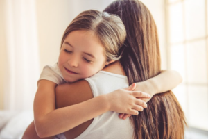 Mother and daughter hugging it out during tooth extraction recovery